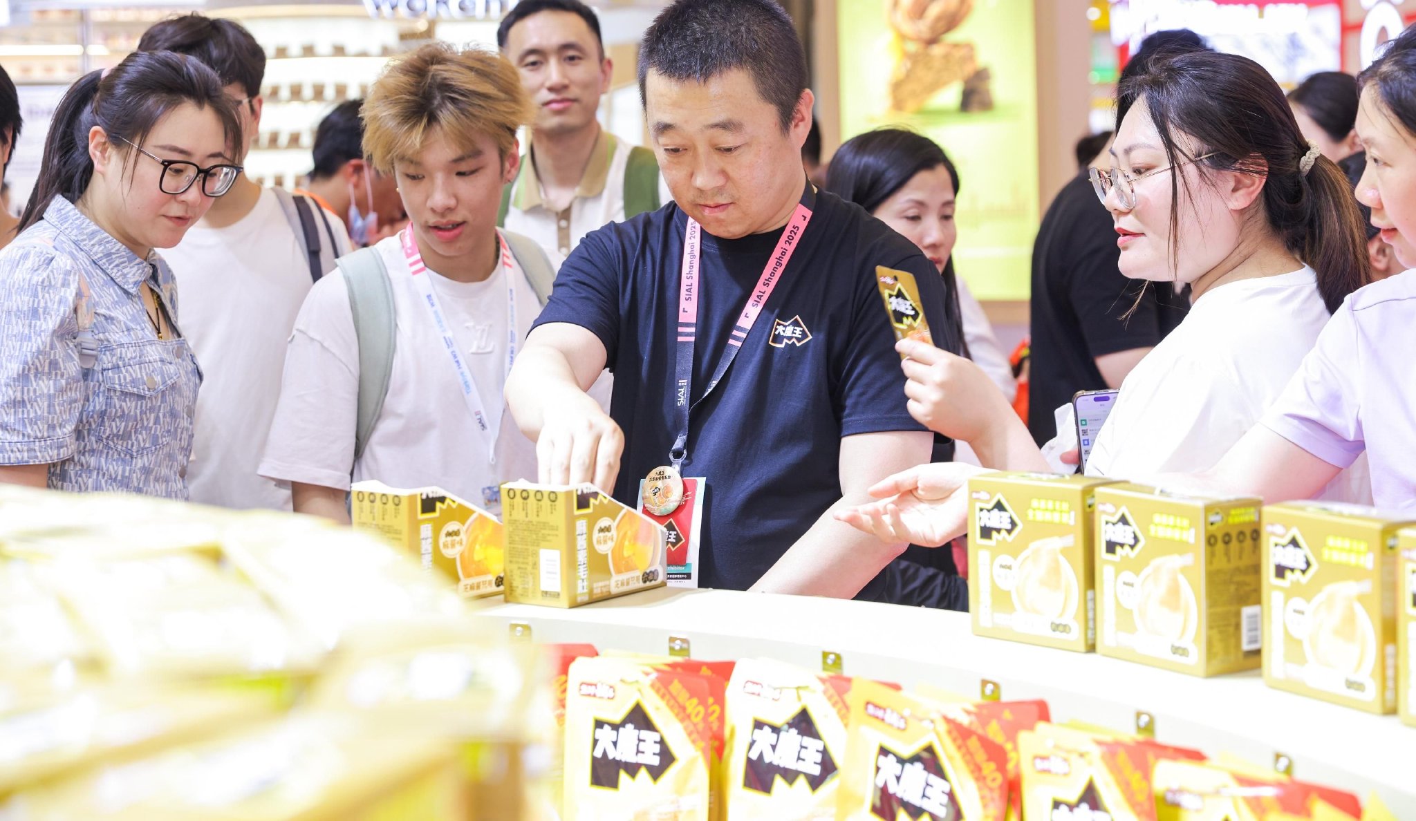 图为2025 SIAL西雅国际食品展现场，参展观众在盐津铺子大魔王馆内排队品尝麻酱素毛肚。企业供图