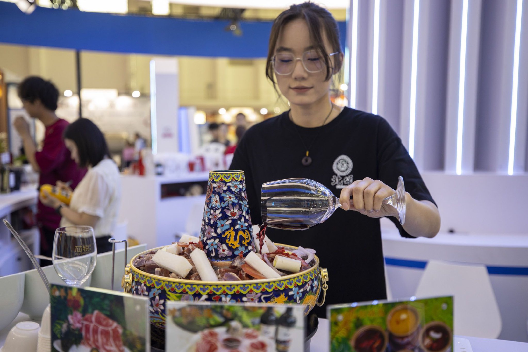 近日,在第五届中国(宁夏)国际葡萄酒文化旅游博览会上,一家参展商的工作人员在烹饪红酒涮肉。新华社记者 杨植森 摄