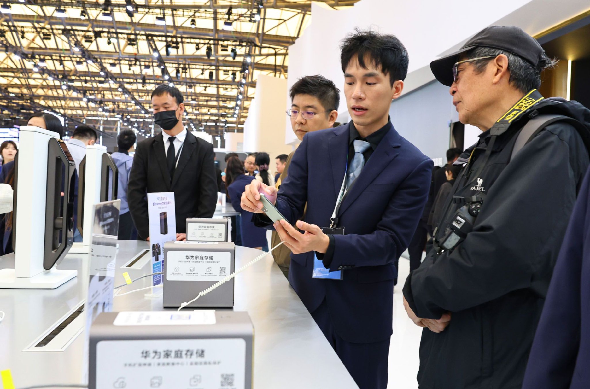 图为在2025中国家电及消费电子博览会上工作人员向参观者介绍一个家庭数据中心存储设备。 新华社记者 方喆 摄