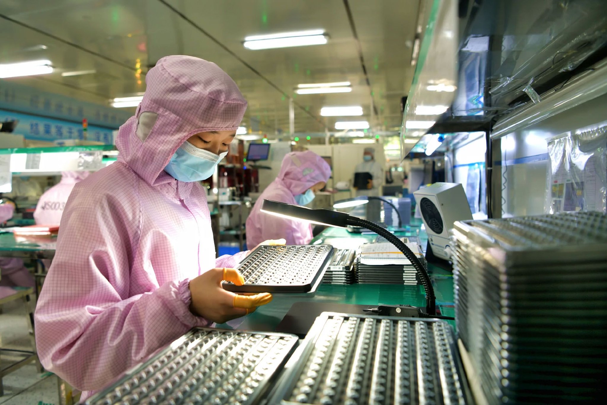 图为位于湖北省咸宁市一家公司的无尘车间内，工人在生产准备出口的智能摄像头模组。 新华社发（刘建平 摄）