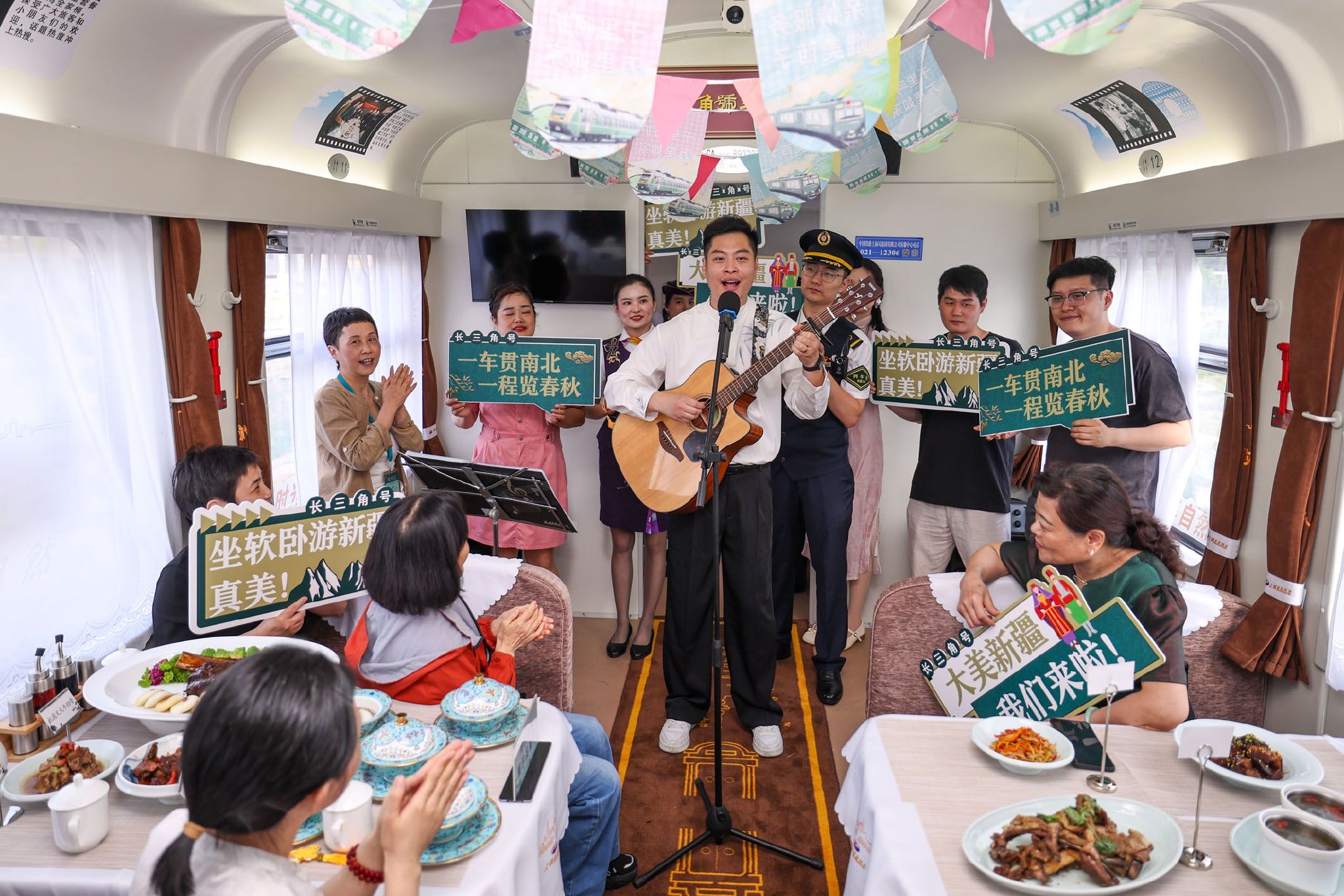 图为杭州客运段列车员在Y476/7次“长三角号”援疆银发旅游专列上为旅客进行文艺表演。新华社记者 江汉 摄