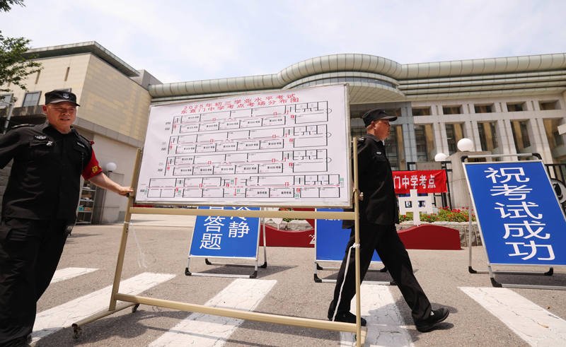 6月23日中午1点半，东直门中学考点校门口，学校工作人员正在进行布置。新京报记者 李木易 摄